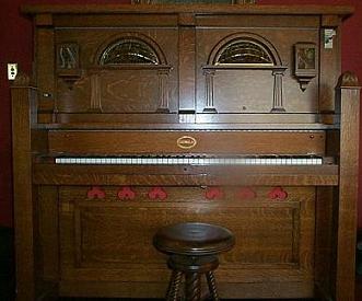 The Coinola X orchestrion with visible piano keys, orchestra bells, and percussion mechanisms