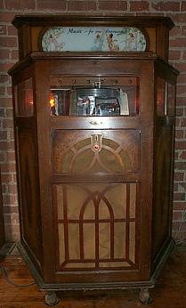 The Electramuse jukebox, a wooden cabinet with a turntable mechanism visible behind glass